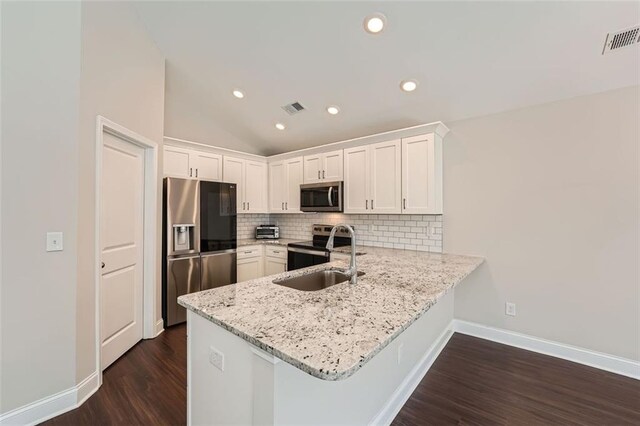 kitchen with white cabinets, sink, dark hardwood / wood-style floors, kitchen peninsula, and stainless steel appliances