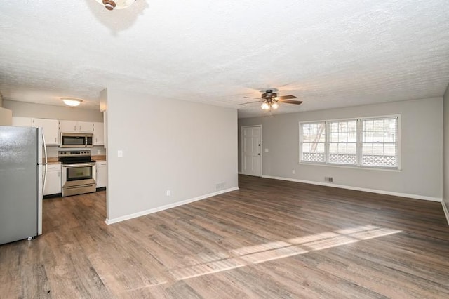 3406 Blackberry Ln, Villa Rica, GA 30180 - unfurnished living room with a ceiling fan, dark wood finished floors, and a textured ceiling