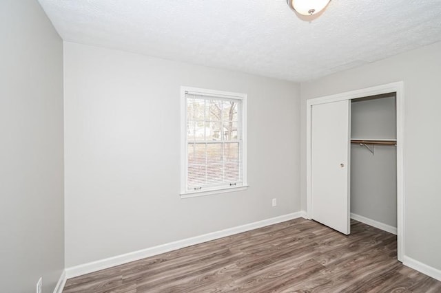 3406 Blackberry Ln, Villa Rica, GA 30180 - unfurnished bedroom with wood finished floors, a closet, and a textured ceiling
