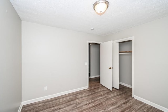 3406 Blackberry Ln, Villa Rica, GA 30180 - unfurnished bedroom with wood finished floors, a closet, and a textured ceiling