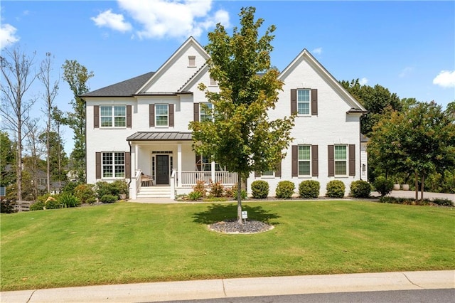 view of front of home featuring covered porch and a front lawn