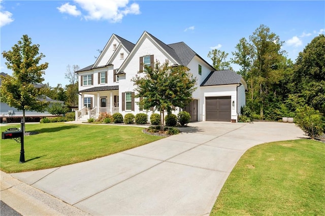 view of front of home with a garage, a front yard, and a porch