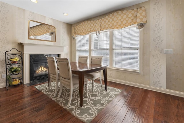 dining space with a fireplace and dark hardwood / wood-style floors