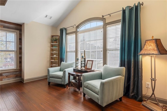 sitting room featuring lofted ceiling, dark wood-type flooring, and a healthy amount of sunlight