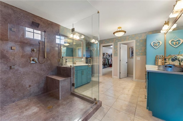 bathroom with walk in shower, vanity, and tile patterned flooring