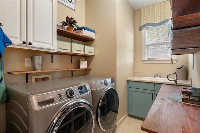 laundry area with cabinets, sink, washing machine and dryer, and light tile patterned flooring