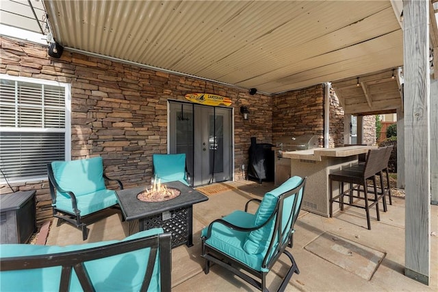 view of patio featuring area for grilling, an outdoor fire pit, and a bar