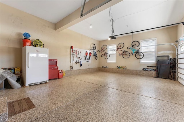 garage featuring a garage door opener and white refrigerator