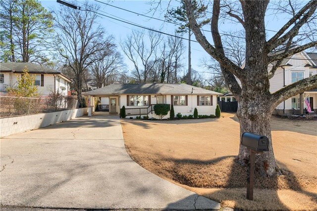 ranch-style home featuring a carport and a porch