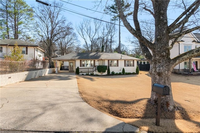 ranch-style house with driveway and fence