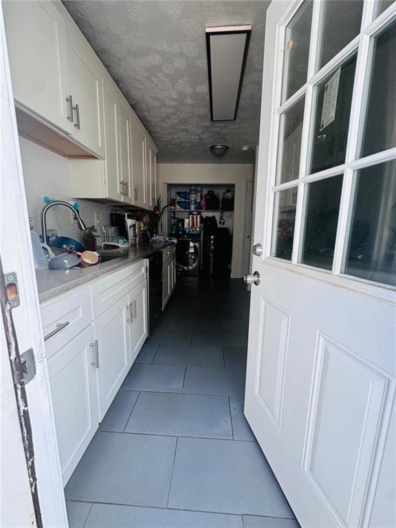 4312 Idlewood Ln, Tucker, GA 30084 - kitchen featuring white cabinetry, dark tile patterned floors, a sink, light countertops, and a textured ceiling