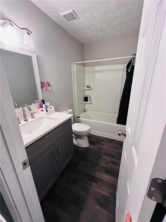 4312 Idlewood Ln, Tucker, GA 30084 - bathroom with vanity, a textured ceiling, wood finished floors, shower / tub combo, and toilet