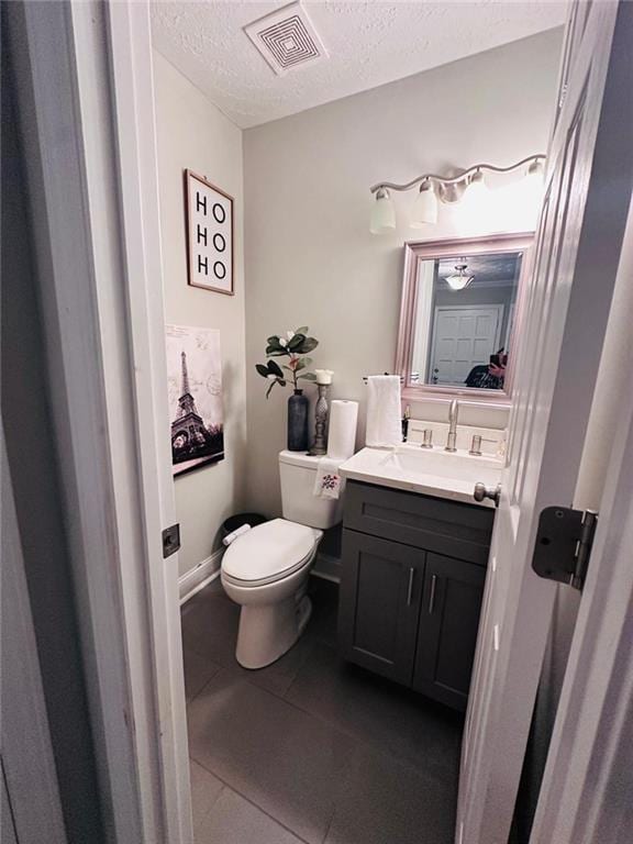 4312 Idlewood Ln, Tucker, GA 30084 - bathroom with a textured ceiling, toilet, vanity, and tile patterned flooring