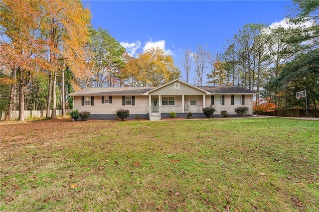 ranch-style home featuring covered porch and a front yard