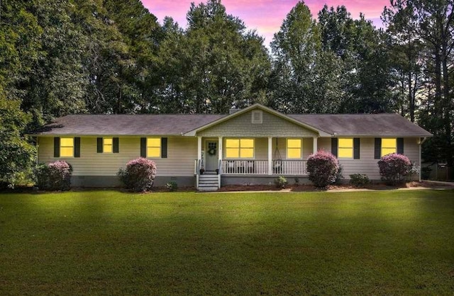 ranch-style home featuring a lawn and covered porch