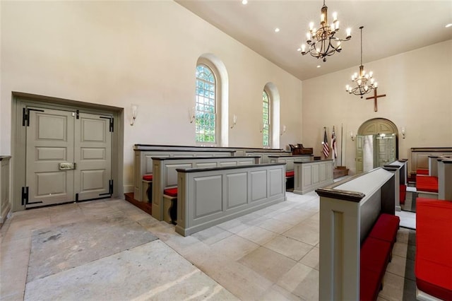 interior space featuring high vaulted ceiling, a chandelier, a kitchen island, hanging light fixtures, and light tile patterned flooring