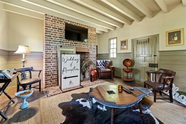 living room featuring beamed ceiling, a healthy amount of sunlight, and light hardwood / wood-style floors