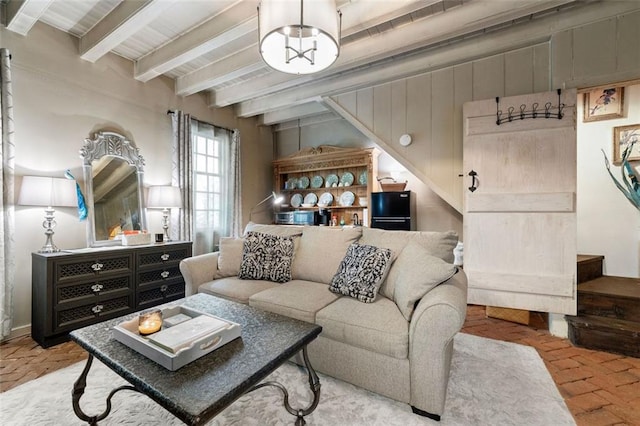 living room with a fireplace, plenty of natural light, and beamed ceiling