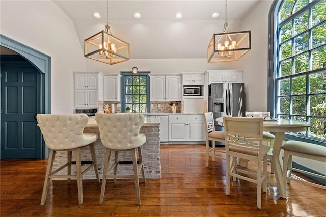 kitchen with a center island, white cabinetry, a wealth of natural light, and vaulted ceiling