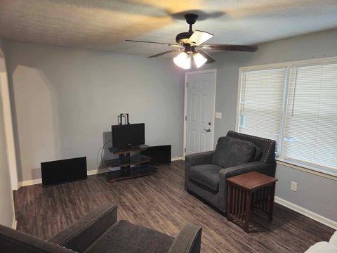 living room featuring hardwood / wood-style floors, ceiling fan, and a textured ceiling