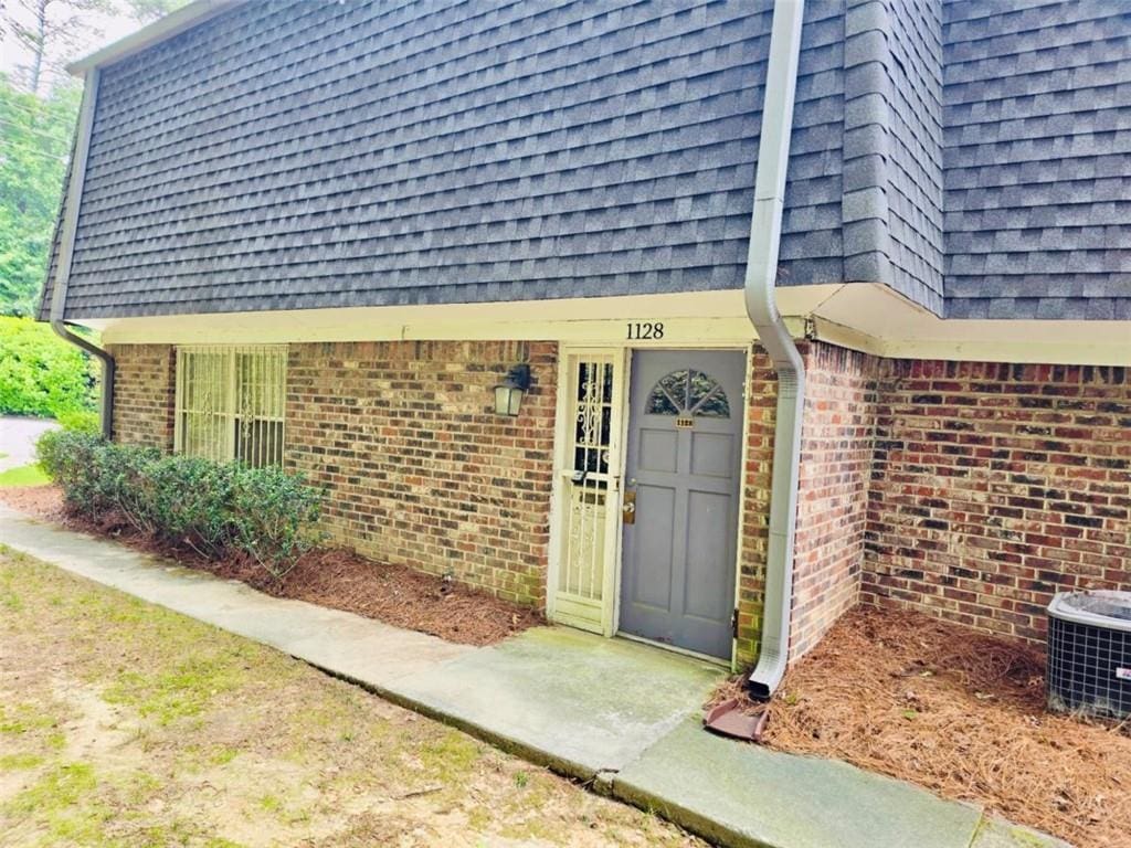1128 Hampton Way, Atlanta, GA 30324 - doorway to property featuring brick siding and roof with shingles
