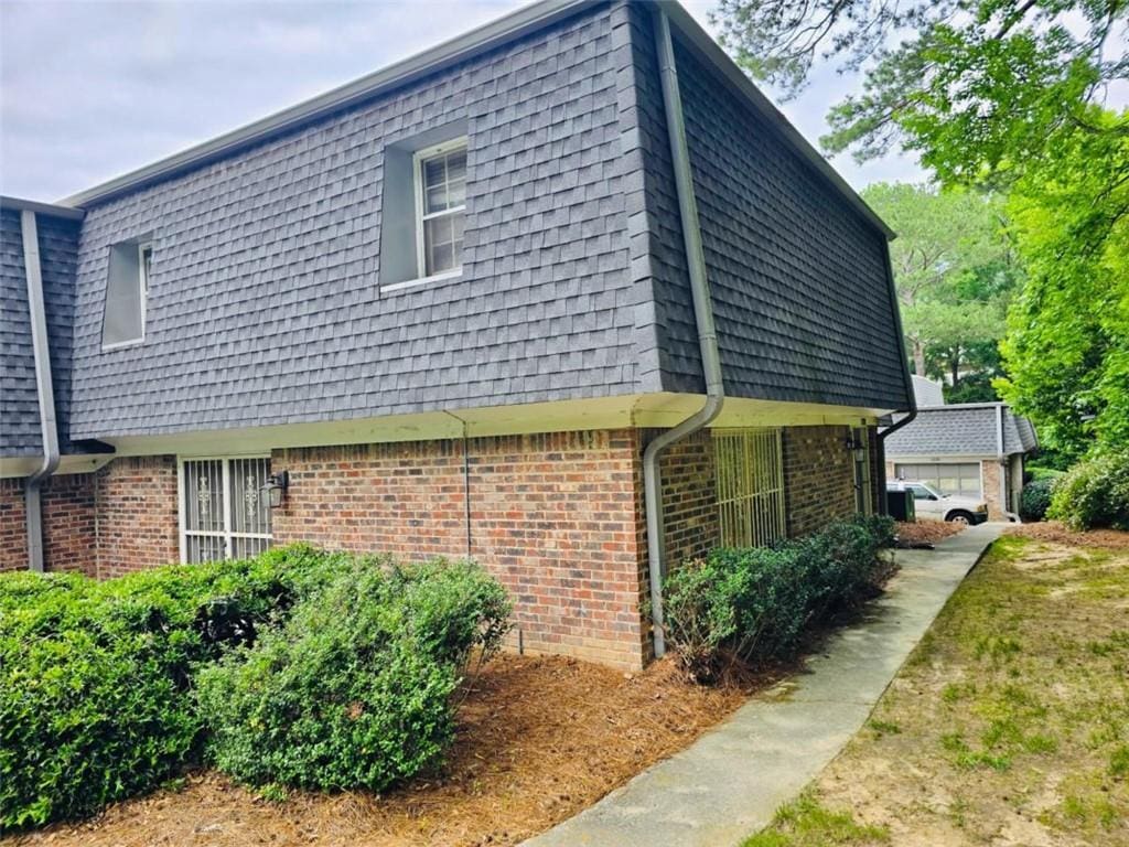1128 Hampton Way, Atlanta, GA 30324 - view of property exterior featuring mansard roof, brick siding, and roof with shingles