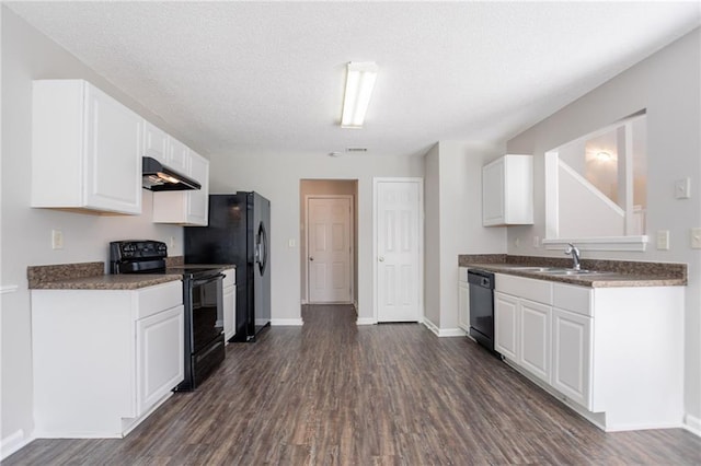 kitchen with black appliances, a sink, under cabinet range hood, dark wood-type flooring, and a textured ceiling