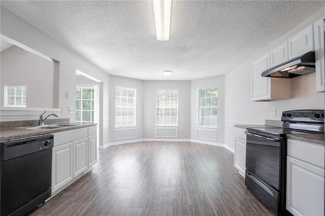kitchen with black appliances, under cabinet range hood, a sink, dark wood finished floors, and white cabinetry