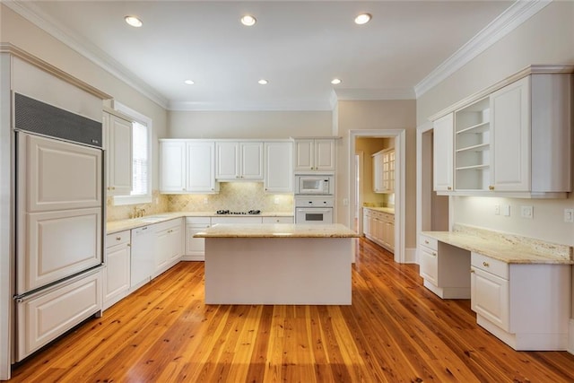 kitchen featuring light stone counters, built in appliances, light hardwood / wood-style flooring, and white cabinetry