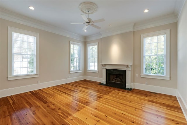 unfurnished living room with ornamental molding, light wood-type flooring, and a wealth of natural light