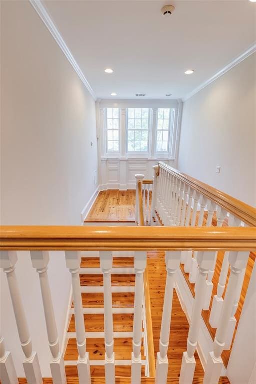 stairway featuring wood-type flooring and ornamental molding