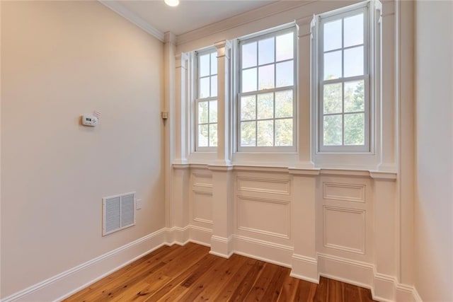 interior space with dark hardwood / wood-style floors and ornamental molding