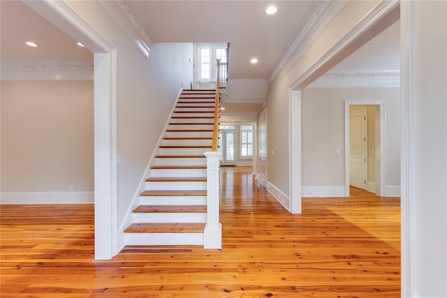 stairs featuring crown molding and hardwood / wood-style floors