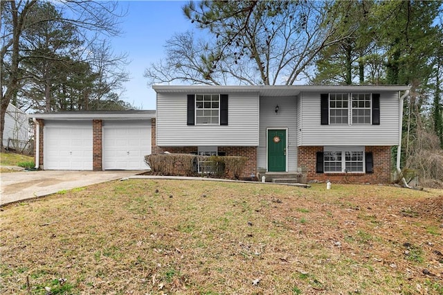 raised ranch featuring a garage, a front lawn, concrete driveway, and brick siding