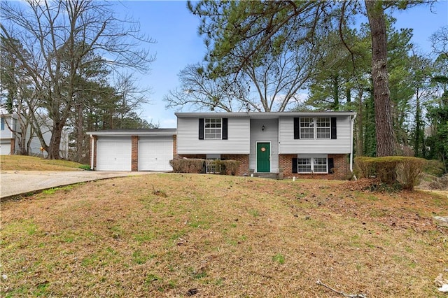 split foyer home featuring driveway, an attached garage, a front yard, and brick siding