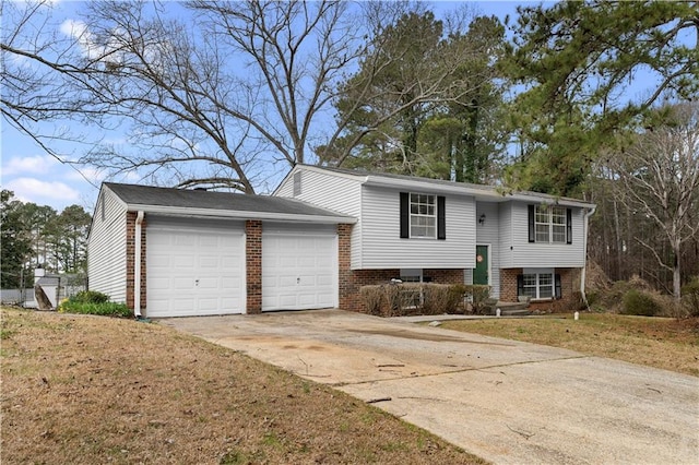 bi-level home with driveway, an attached garage, a front lawn, and brick siding