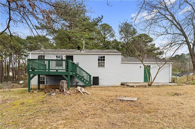 rear view of property with fence, stairway, and a wooden deck