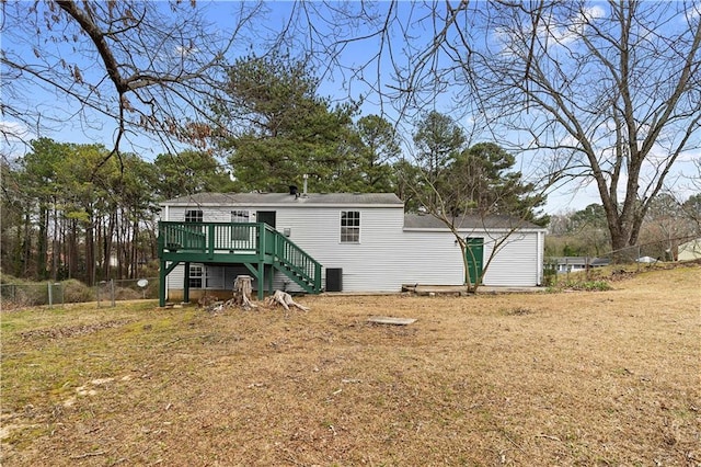 back of property featuring fence, stairway, a lawn, and a wooden deck