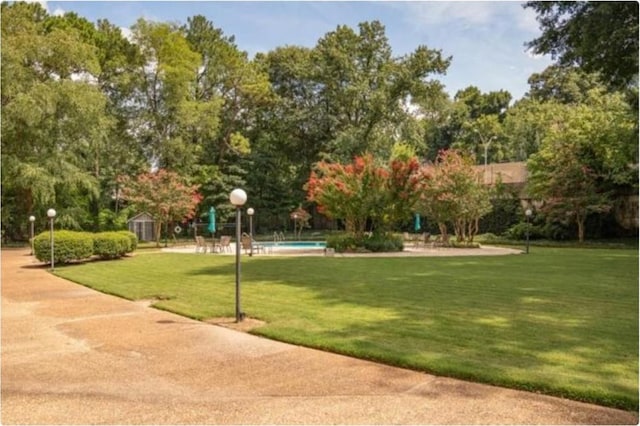 view of home's community with a yard and a storage shed