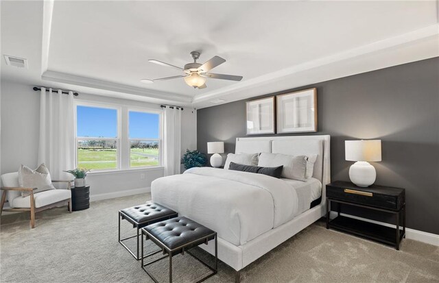 bedroom with ceiling fan, visible vents, carpet floors, a raised ceiling, and baseboards