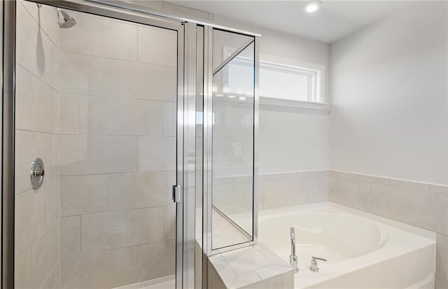 bathroom featuring a bath and a stall shower