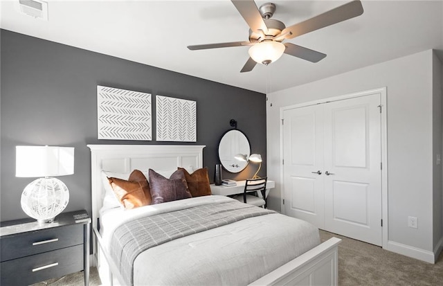 bedroom with visible vents, baseboards, a closet, a ceiling fan, and light carpet