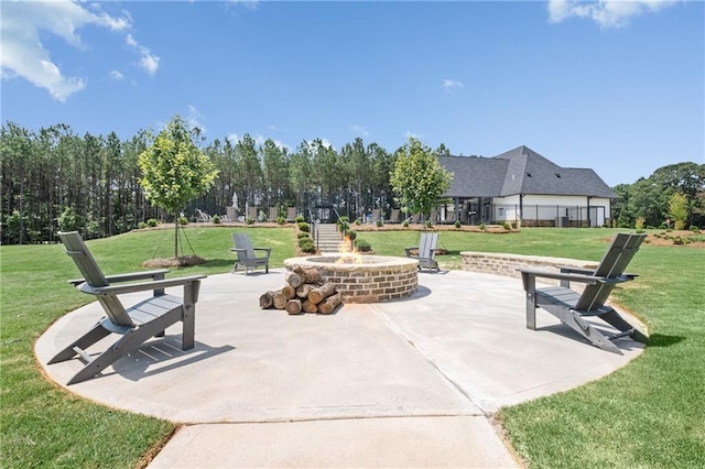 view of home's community with an outdoor fire pit, a yard, and a patio area