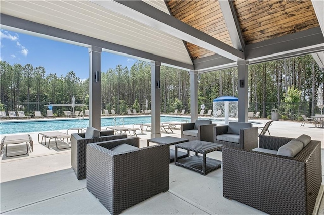 view of patio / terrace with a community pool, outdoor lounge area, and fence