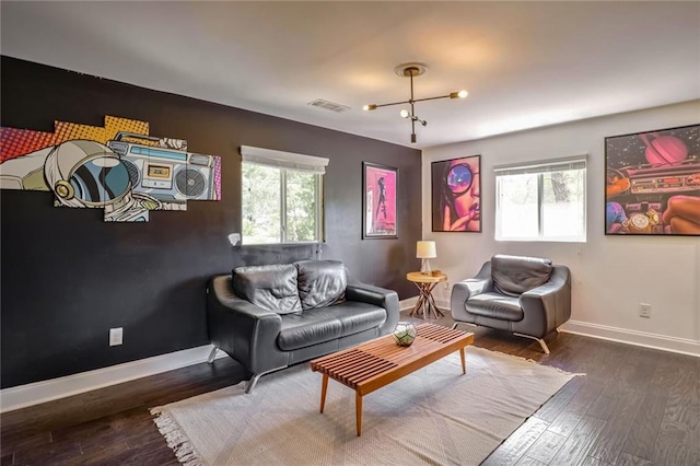 living room featuring dark hardwood / wood-style flooring and an inviting chandelier