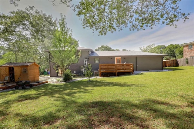 back of house featuring a wooden deck, a shed, and a lawn