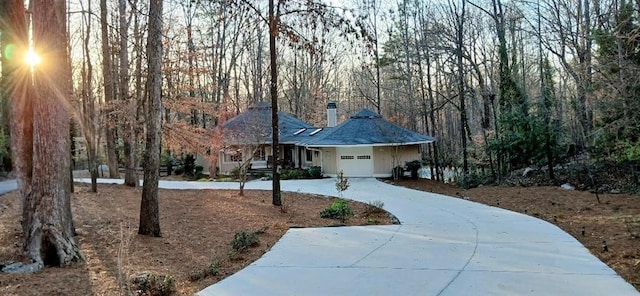 ranch-style house featuring an attached garage and curved driveway