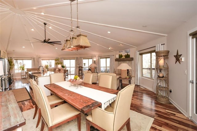 dining room featuring a healthy amount of sunlight, vaulted ceiling, wood finished floors, and recessed lighting