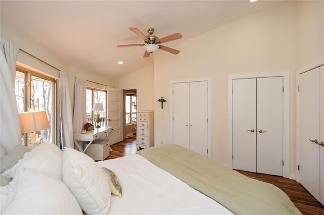 bedroom with high vaulted ceiling, dark wood-type flooring, two closets, and recessed lighting