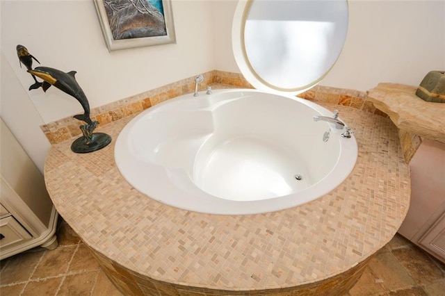 bathroom featuring a tub to relax in and stone tile flooring